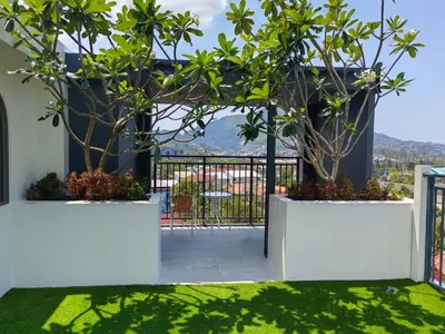 a balcony with two potted trees in white planters at Premium 2BR near Kamala Beach, Pool, Gym & Shuttle Bus in Phuket Town