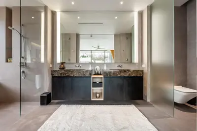 a bathroom with a sink and a toilet and a mirror at Luxury Penthouse 407sqm Beachfront and private pool in Phuket Town
