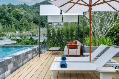 a patio with an umbrella and a pool at Luxury Penthouse 407sqm Beachfront and private pool in Phuket Town