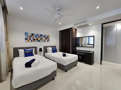 a hotel room with two beds and a television at Stylish 2 Bedroom Apartment with pool access in Surin in Surin Beach