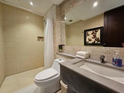 a bathroom with a white toilet and a sink at Stylish 2 Bedroom Apartment with pool access in Surin in Surin Beach