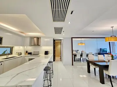a kitchen and dining room with a table and chairs at Stylish 2 Bedroom Apartment with pool access in Surin in Surin Beach