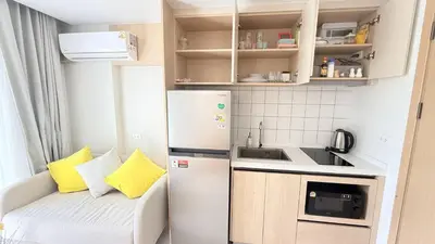 a small kitchen with a white refrigerator and a couch at Fantasea Kamala 1 BR Near Fantasea Show & Beach 505 in Phuket Town