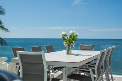 a table with chairs and a vase with flowers on it at \u5361\u9a6c\u62c9\u6d77\u6ee9\u4e00\u7ebf\u6d77\u666f6\u5367\u522b\u5885 \u5df4\u4e1c\u9152\u5427\u885710\u5206\u949f\u5230\u8fbe\u76f4\u901a\u6d77\u6ee9\u5bb6\u6d77\u666fspa\u6f02\u6d6e\u8336 in Phuket Town