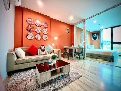a living room with a couch and a bedroom at The Base Height Condo with Rooftop infinity pool in Ban Sam Kong