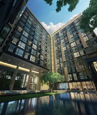 a large building with a tree in front of it at The Base Height Condo with Rooftop infinity pool in Ban Sam Kong
