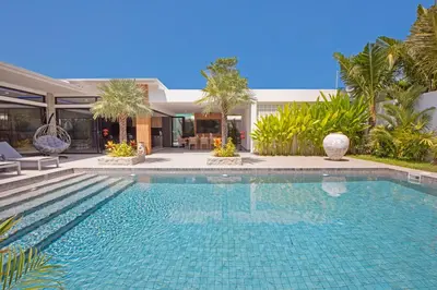 a swimming pool in front of a house at Stylish 4 bdrs new brand pool villa at Rawai kokmakham 1 in Rawai Beach