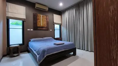 a bedroom with a bed and two windows at Rosemary Phuket in Ban Tha Rua
