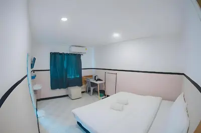 a hospital room with a bed and a blue curtain at XX Mitr Inn - Phuket Old Town in Phuket Town