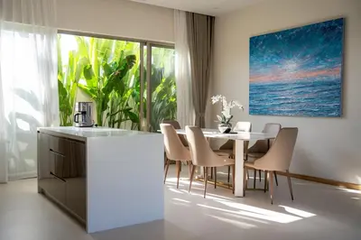 a kitchen and dining room with a table and chairs at Modern 3BR Pool Villa T-Breeze in Laguna Phuket