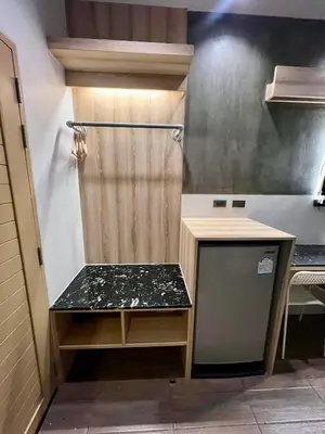 a small kitchen with a counter and a refrigerator at Bang Tao cozy studio in Ban Thalat Choeng Thale