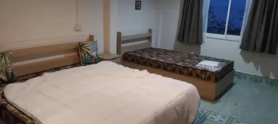 a bedroom with two beds and a window at Water's Edge Resort , in Panwa Beach