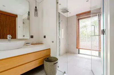 a bathroom with a sink and a glass shower at Stylish Mansion for Leisure with Garden & Pool in Laguna Phuket