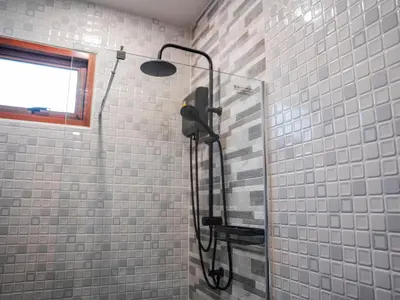 a shower in a bathroom with white tiled walls at 3 Bedroom Villa with Pool near Fitness street in Ban Klang