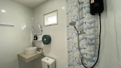 a white bathroom with a shower and a toilet at Suntalee House in Nai Yang Beach
