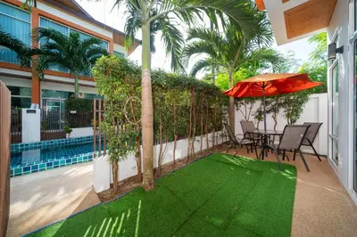 a patio with an umbrella and a table and chairs at AP Nest Villas Residence - Tropical Pool Access, near Kamala Beach in Kamala Beach