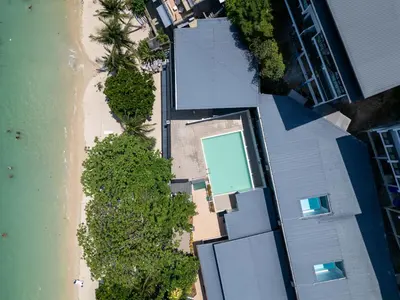an overhead view of a beach with trees and a building at The Hideout Beachfront in Patong Beach