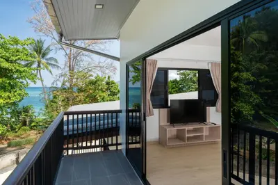 a room with a balcony with a view of the ocean at The Hideout Beachfront in Patong Beach
