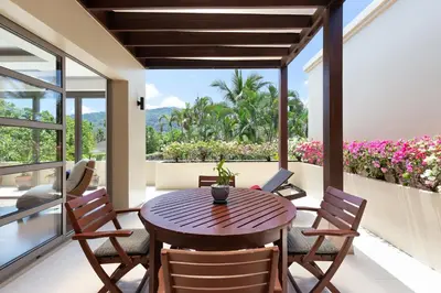 a dining room with a table and chairs on a balcony at The Residence Bangtao Villa 216 in Bang Tao Beach