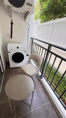 a balcony with a microwave and a table and a chair at Fantasea Condo Kamala beach 1BR apart B1 in Kamala Beach