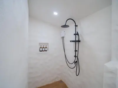a shower in a white bathroom with a shower head at Leivi Villa 3 bedrooms in Rawai Beach