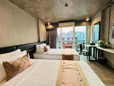 a hotel room with two beds and a balcony at Aspira Central Patong in Patong Beach