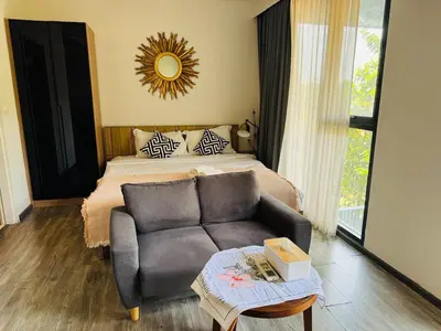 a bedroom with a couch and a bed and a mirror at Patong city-center pool cozy condo in Patong Beach