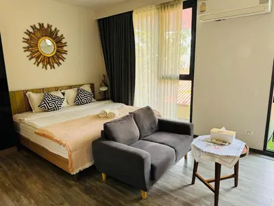 a bedroom with a bed and a couch and a chair at Patong city-center pool cozy condo in Patong Beach