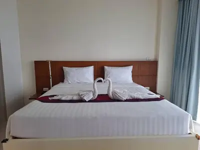a bed with two white towels on it at At the tree by fatimah Rawai 408 in Rawai Beach