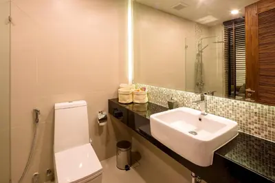 a bathroom with a sink and a toilet and a mirror at At the tree by fatimah Rawai 408 in Rawai Beach
