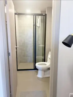 a bathroom with a toilet and a glass shower at Dcondo reef 99 in Kathu