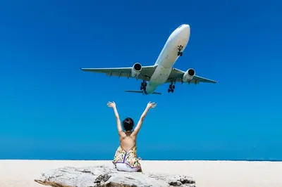 a person sitting on a beach with an airplane at Blissful Living & Tropical Vibes - 3BR Pool Access Villa Argent 9, just 15 min drive from Nai Yang and Nai Thon Beaches in Thalang