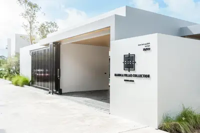 a white house with a black door at MANDLA VILLAS COLLECTION, White Anda Naiharn in Rawai Beach