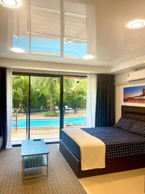 a bedroom with a large bed and a swimming pool at Palm Breeze View in Ban Mai Salae