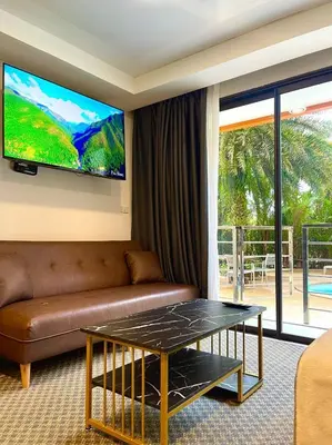 a living room with a couch and a tv at Palm Breeze View in Ban Mai Salae