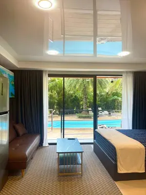a hotel room with a bed and a couch and a pool at Palm Breeze View in Ban Mai Salae