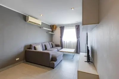 a living room with a couch and a television at Modern Condo - 1BR T1 -501 in Chalong