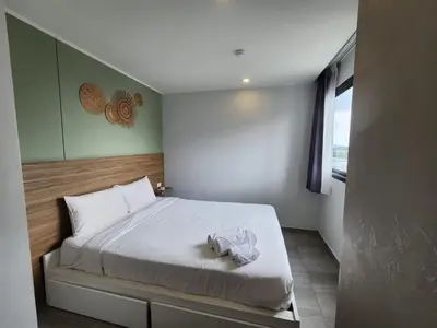 a bedroom with a bed with white sheets and a window at Cozy Apt-1BR T3-635 in Chalong