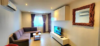 a living room with a couch and a tv at Modern Condo - 1BR T1-401 in Chalong