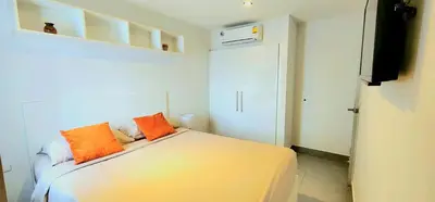 a bedroom with a bed with two orange pillows on it at Modern Condo - 1BR T1-401 in Chalong