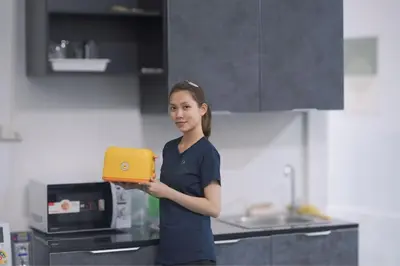 a young girl holding a tablet in a kitchen at Comfort Hostel Phuket Old Town by MaTong in Phuket Town