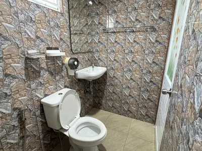 a bathroom with a toilet and a sink at Jampathong mansion in Ban Bo Han