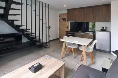 a kitchen and dining room with a table and a staircase at Duplex Naiharn UTL A123 - Perfect Stay near Beach in Rawai Beach