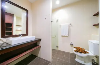 a bathroom with a sink and a toilet and a mirror at EBS Hostel Phuket in Karon Beach