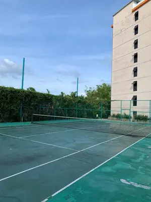 a tennis court in front of a building at Студия мечтателя in Mai Khao Beach