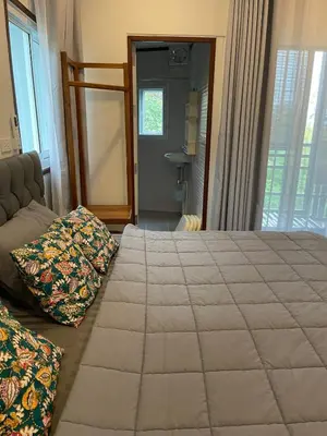 a bedroom with a bed and a couch and a window at Baan Sangchai Beach in Ko Bon