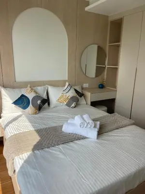 a large bed with two towels on top of it at Two-bedrooms apartments with kitchen in Phuket Town