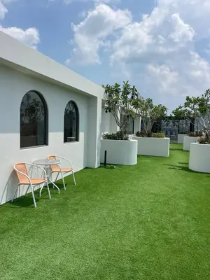a patio with a table and chairs on grass at Two-bedrooms apartments with kitchen in Phuket Town