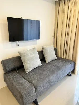 a couch with two pillows and a flat screen tv at New apartment with mountain view in Ban Mai Salae