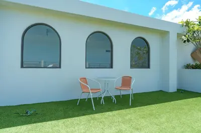 a room with a table and chairs on the grass at Kamala Beach View 1 BdR Roof Pool 500 mbps WiFi in Kamala Beach